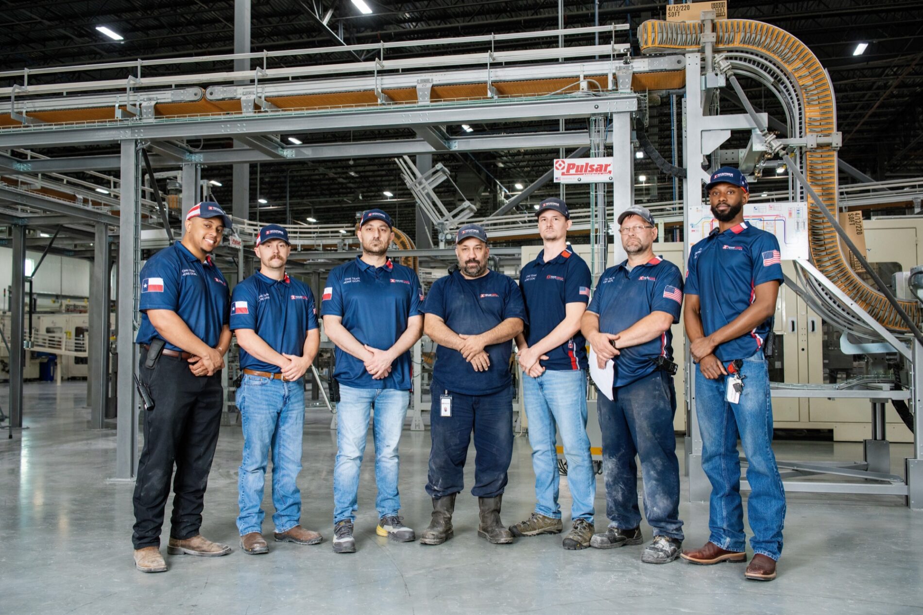 Production team standing in front of converting machinery